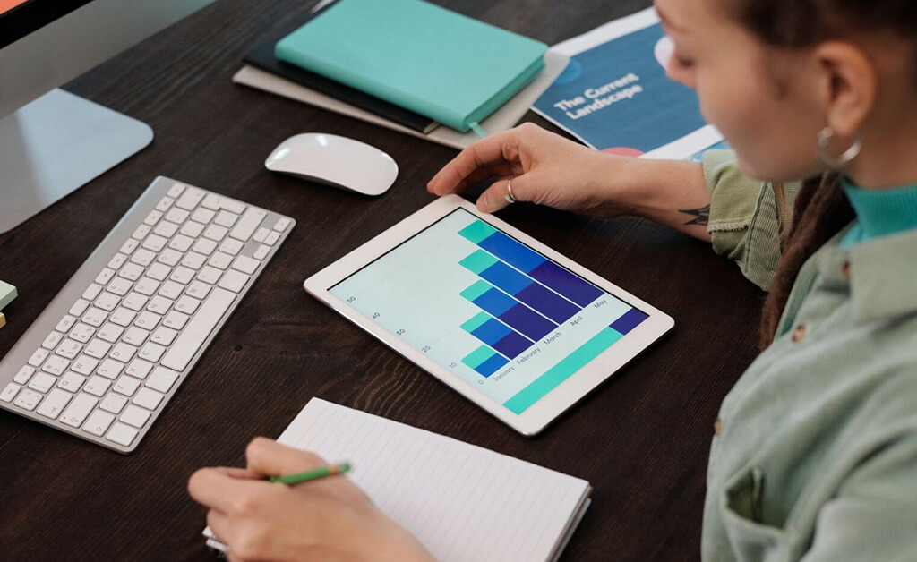 A woman analysing graphs and data digitally with an ERP solution.